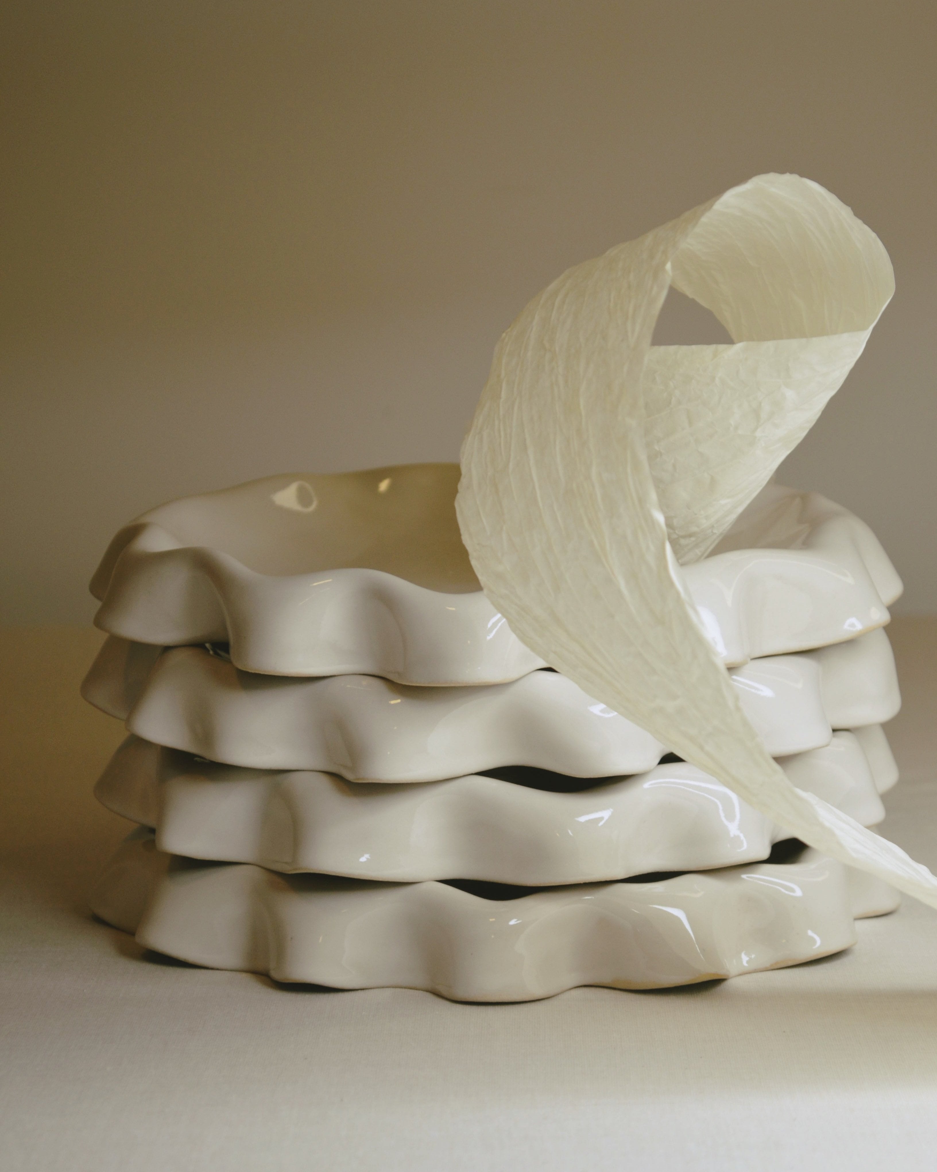 Assiette blanc cassé aux bords ondulés.