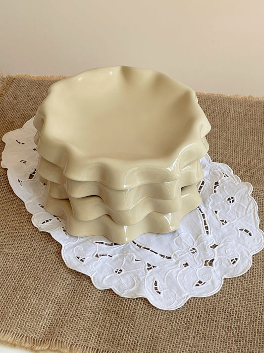 Assiette jaune aux bords ondulés.