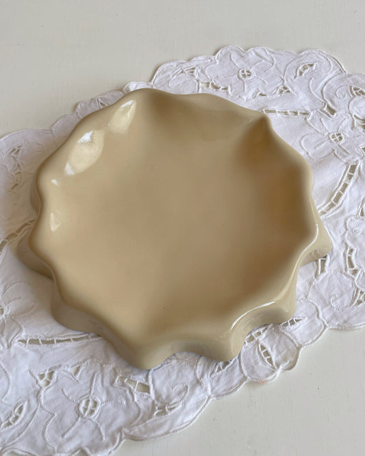Assiette jaune aux bords ondulés.