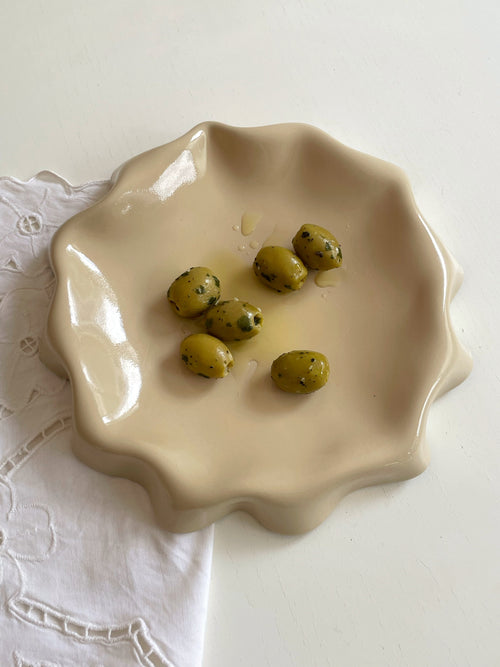 Assiette jaune aux bords ondulés.