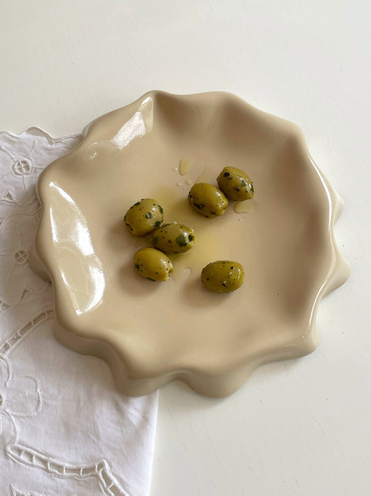 Assiette jaune aux bords ondulés.
