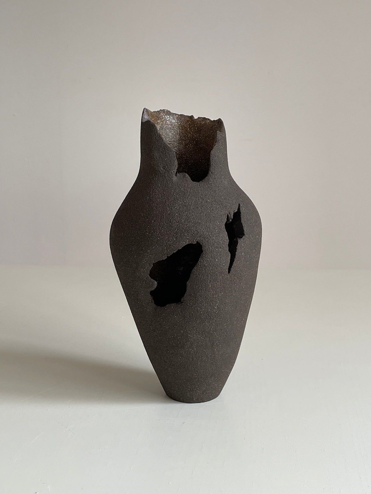 Vase en céramique avec percée asymétrique.